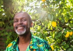 Senior African American man smiling among a background of trees