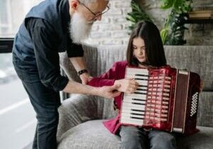 Elderly man teaching a young accordion student