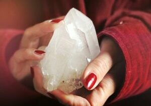 A woman's hands holding a large crystal